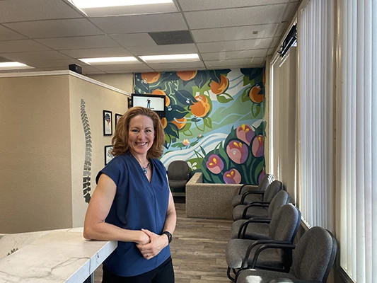 Chiropractor-Morgan-Hill-CA-Nicole-Conragan-Leaning-on-Front-Desk